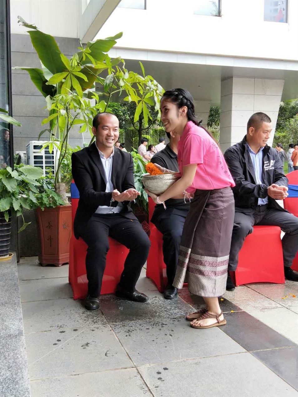 老撾駐廣西留學(xué)生代表將浸有花瓣的香水灑客人的手上，表示對(duì)嘉賓的美好祝福（圖一）