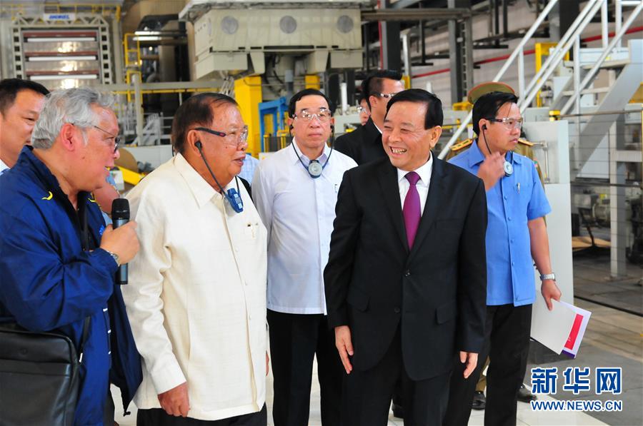 3月10日，在老撾沙灣拿吉省車邦縣，老撾人民革命黨中央總書(shū)記、國(guó)家主席本揚(yáng)（左二）在山東太陽(yáng)紙業(yè)股份有限公司董事長(zhǎng)李洪信（右二）的陪同下視察公司。 新華社記者章建華攝